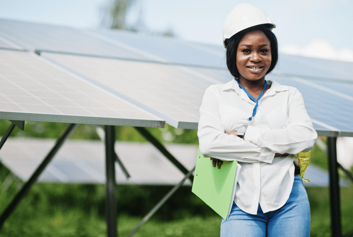 female engineer smiling in front of solar panels